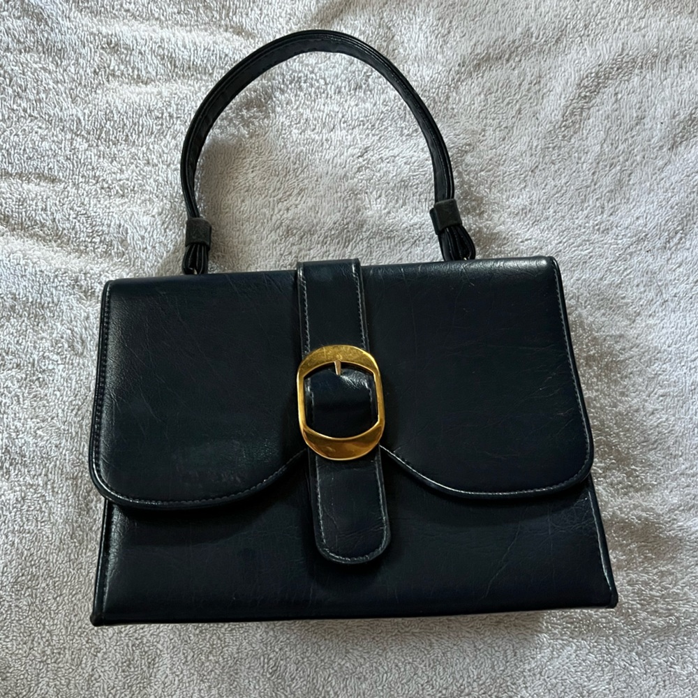 Super cute vintage navy leather handbag with brass clasp.